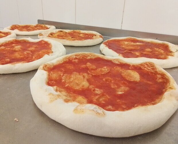 Bases de pizza. Bases de pizza con tomate, estiradas a mano